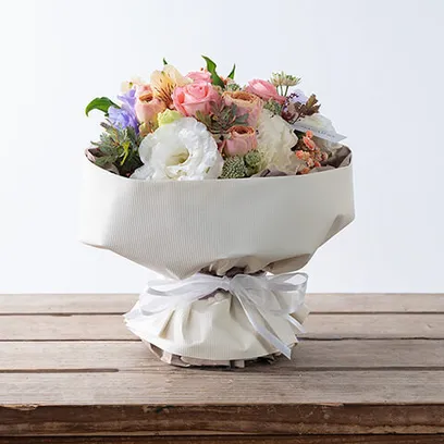 淡いピンク系で白ラッピングのスタンディングブーケ